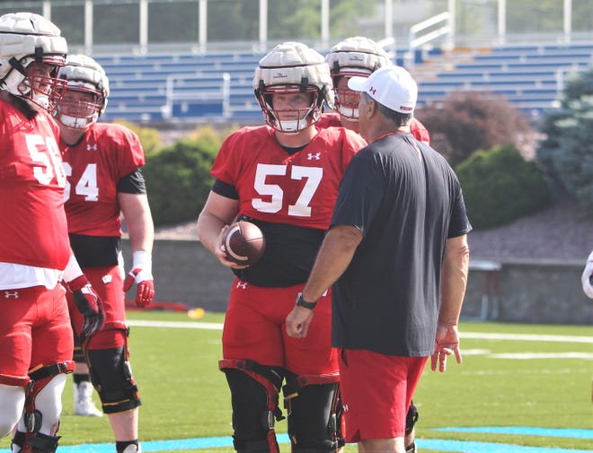 Wisconsin center Jake Renfro (57) talks with offensive line coach Jack Bicknell Jr. during the team's practice on Saturday Aug. 5, 2023 at Pioneer Stadium on the campus of UW-Platteville.