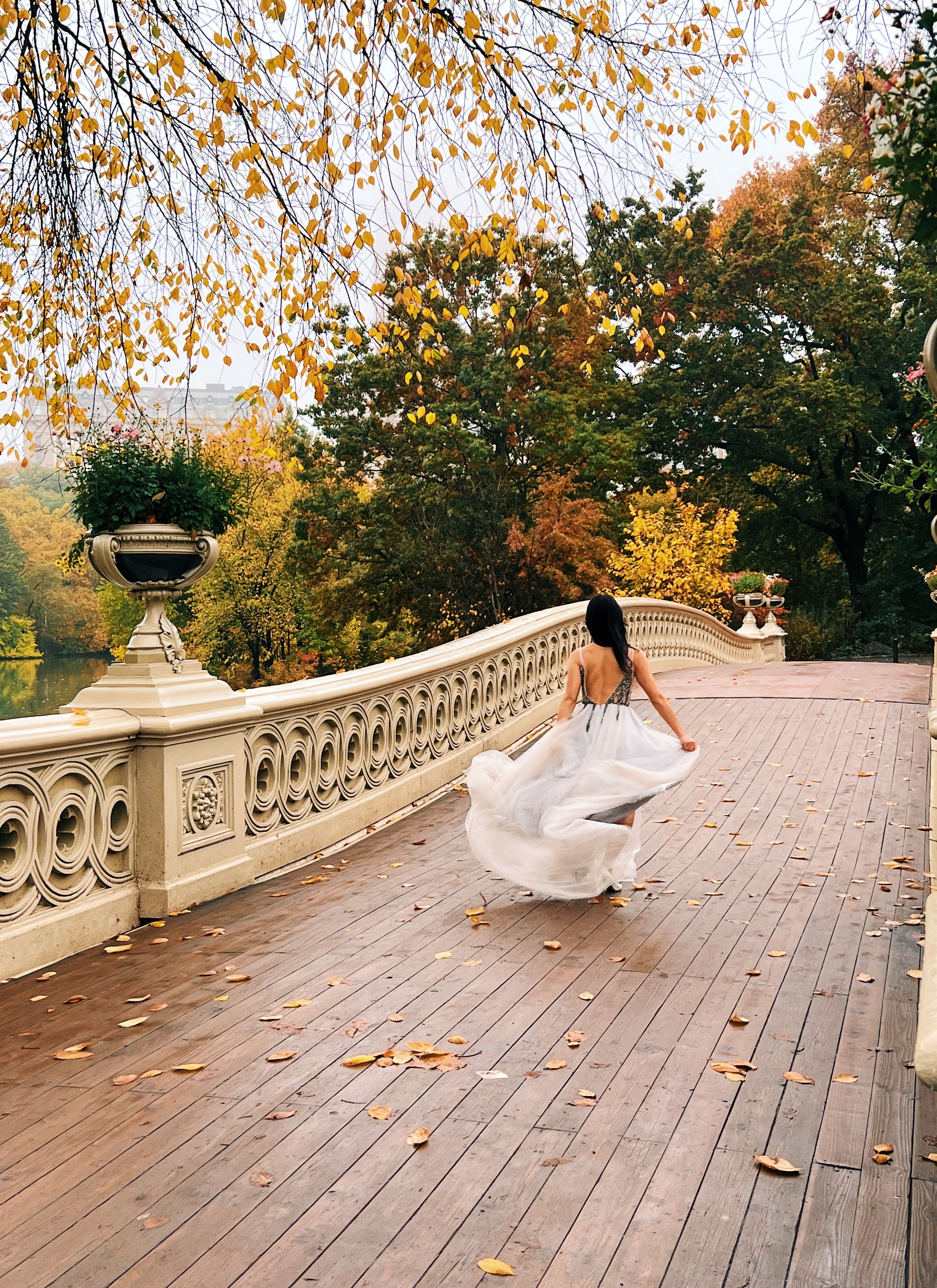 Seorang wanita dengan gaun pesta berlari di jembatan di Central Park