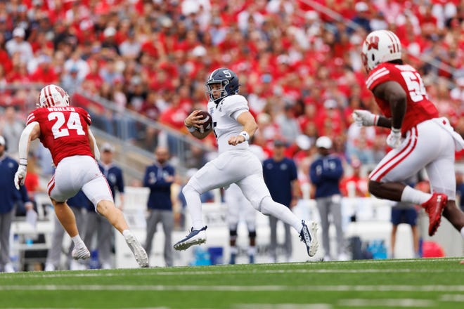 Georgia Southern quarterback Davis Brin (5) rushes with the football between Wisconsin Badgers safety Hunter Wohler (24) and linebacker Jordan Turner (54) during the second quarter at Camp Randall Stadium.